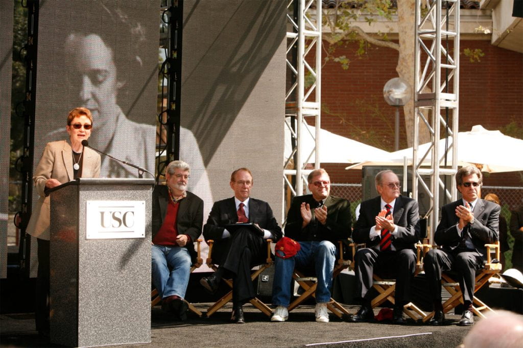 Elizabeth M. Daley is seen on stage with George Lucas, USC President Steven Sample, Robert Zemeckis, Frank Price and Paul Junger Witt to celebrate the renaming of the USC School of Cinematic Arts